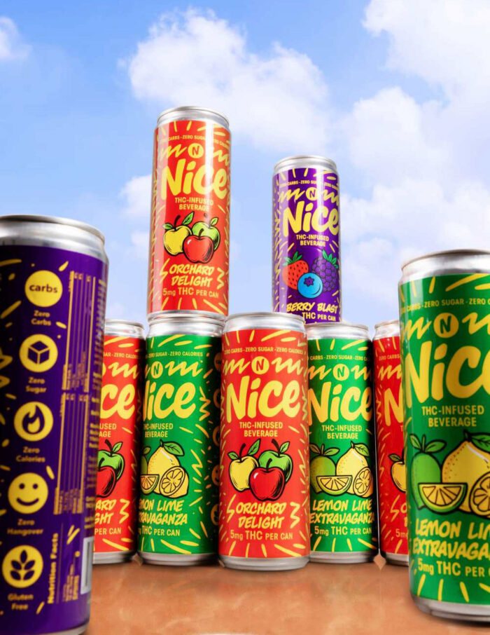 Berry, orchard and lemon lime NICE cans stacked outdoors against a blue sky